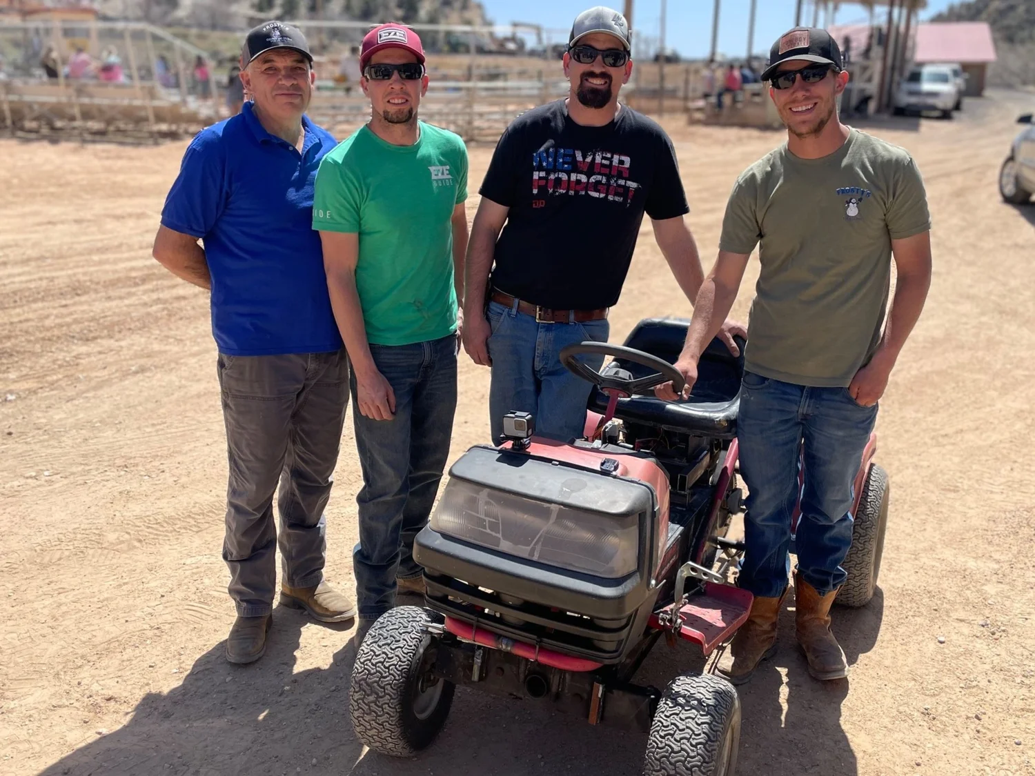 Four of the family crew around a modified racing lawn mower at a dirt arena